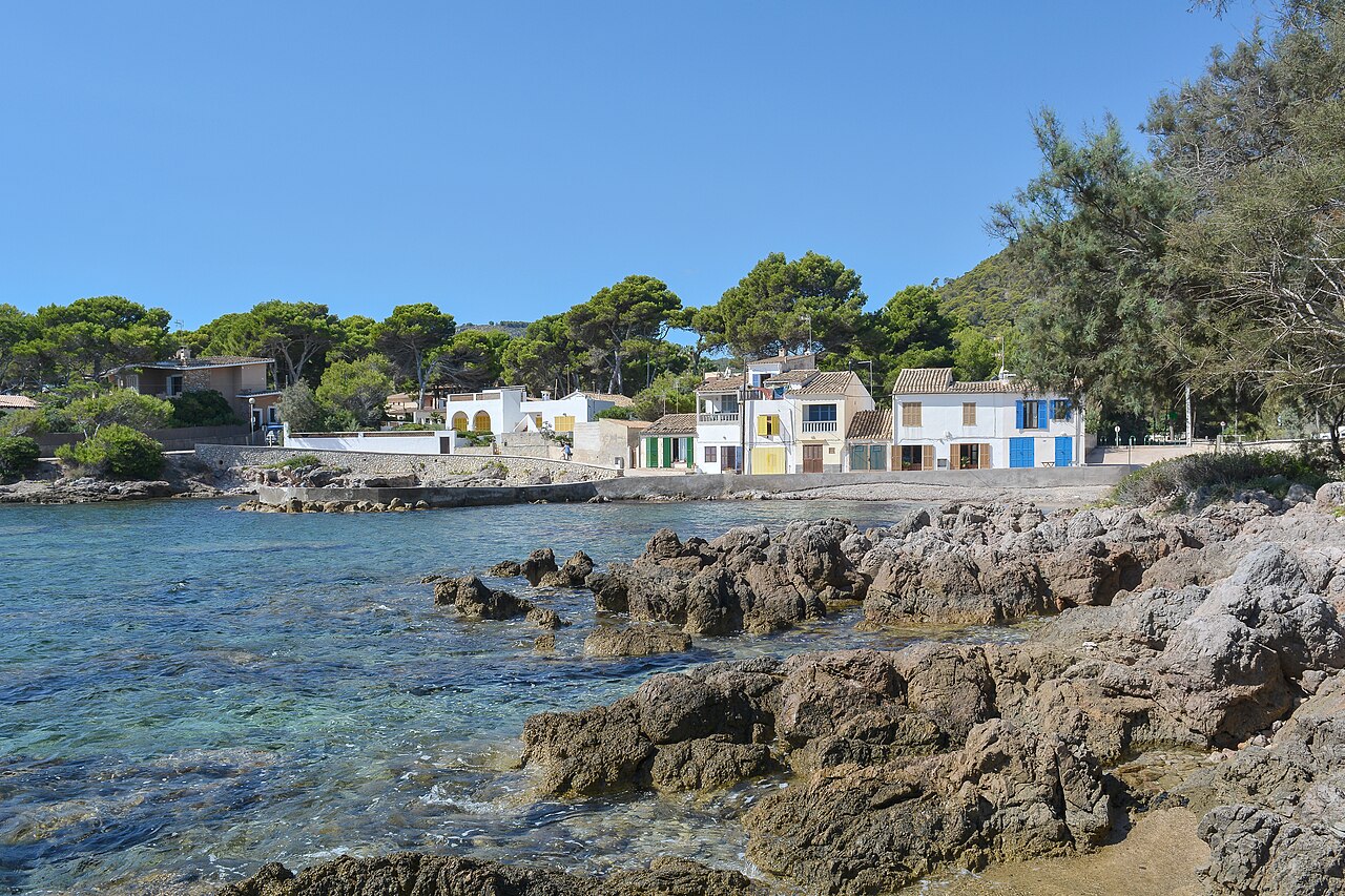 Stille Felsbucht mit klarem türkisem Wasser und kleinen Fischerhäusern an der Ostküste von Mallorca