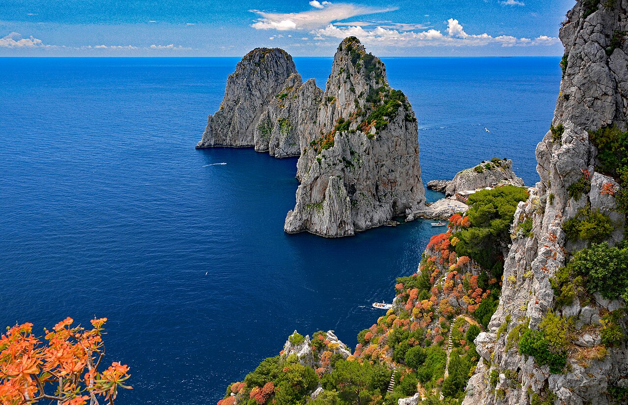 Die Faraglioni-Felsen von Capri ragen aus dem tiefblauen Tyrrhenischen Meer, im Vordergrund die Steilküste
