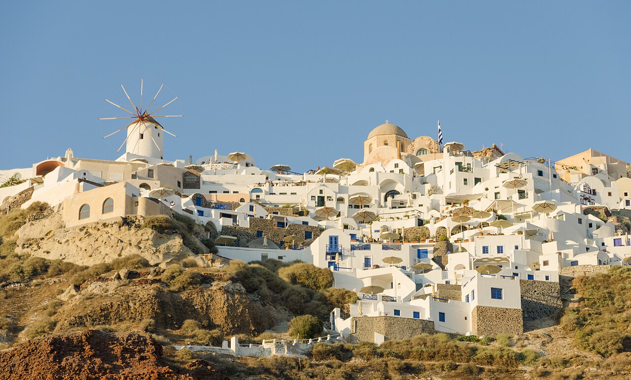 Weiße Häuser am Calderarand von Oia auf Santorini, alle mit Blick aufs Meer
